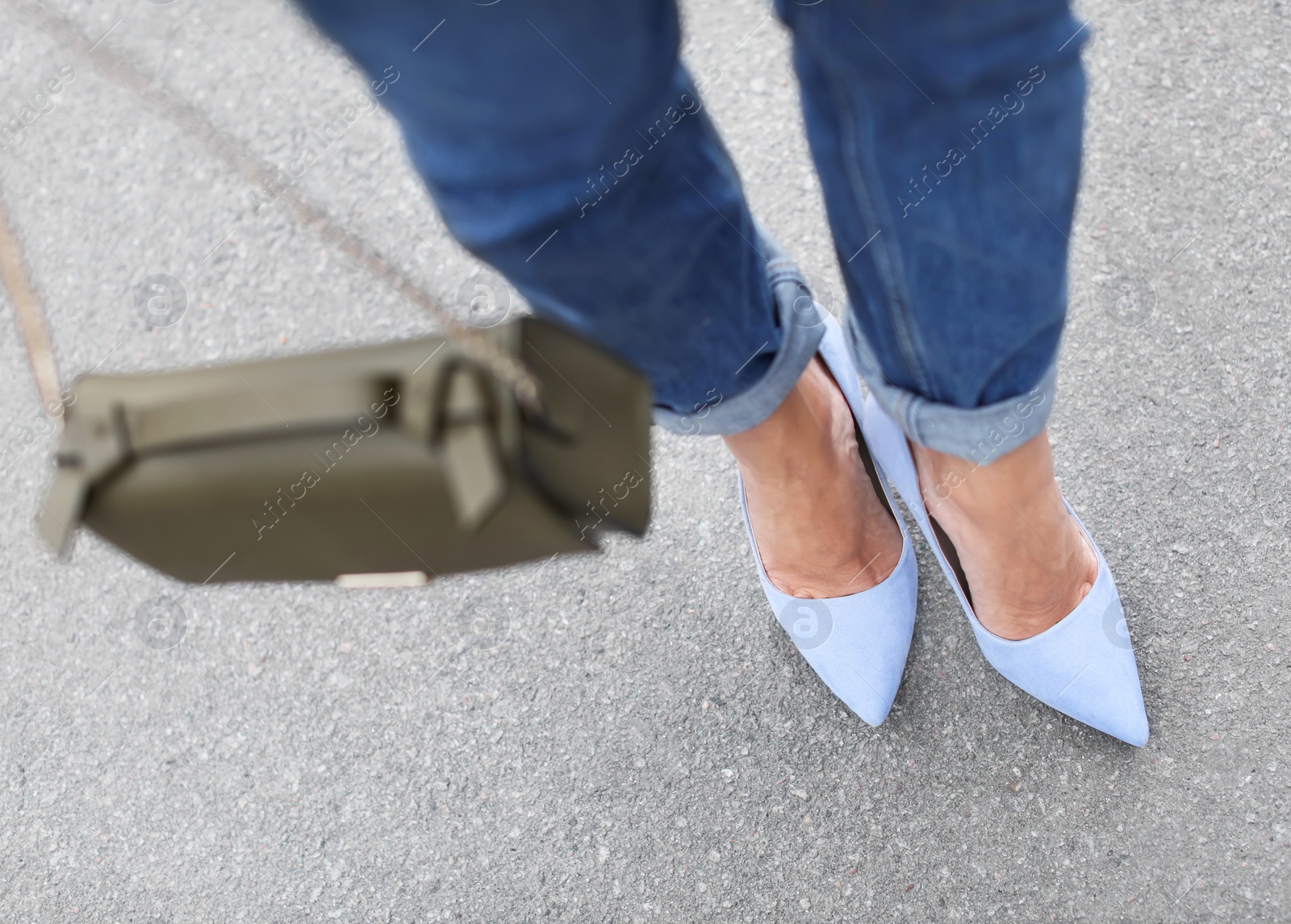 Photo of Young woman in elegant shoes walking on street