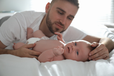 Photo of Father with his newborn son at home