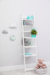 Stylish shelving unit near light wall in child room