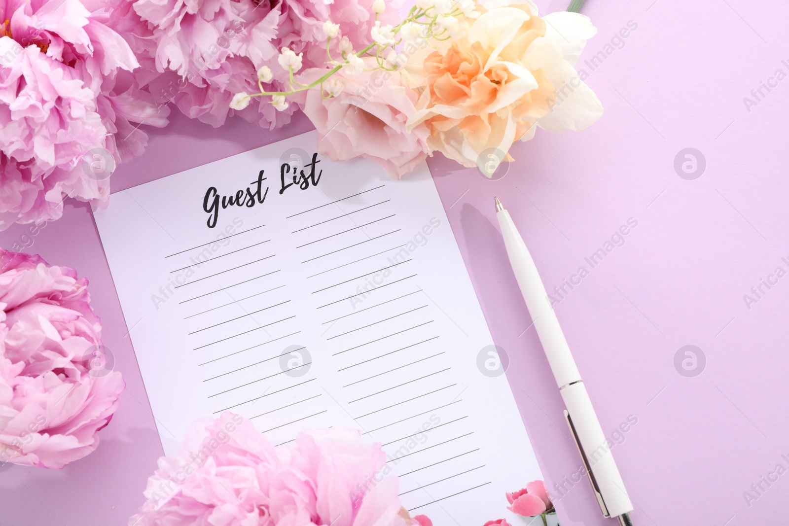 Photo of Guest list, pen and beautiful flowers on violet background, flat lay. Space for text