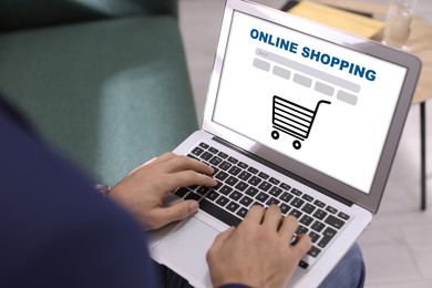 Image of Man using laptop for online shopping on sofa indoors, closeup