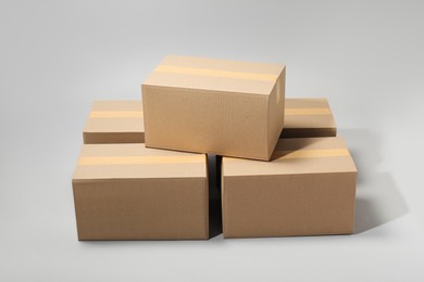 Many closed cardboard boxes with tape on light grey background