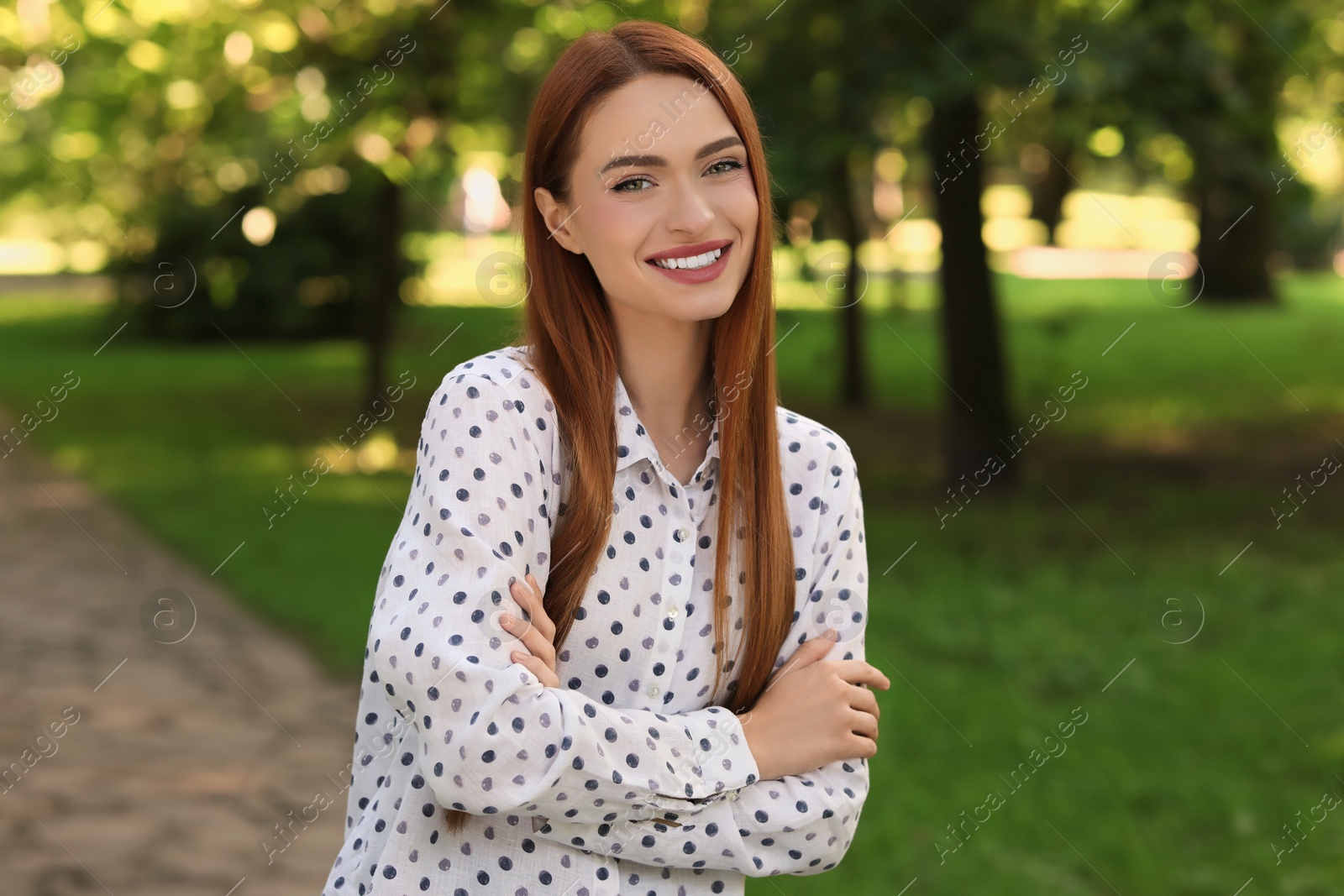 Photo of Portrait of charming young woman with beautiful smile in park. Attractive lady posing for camera