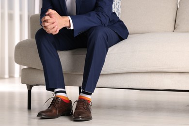 Photo of Man wearing stylish shoes and colorful socks indoors, closeup