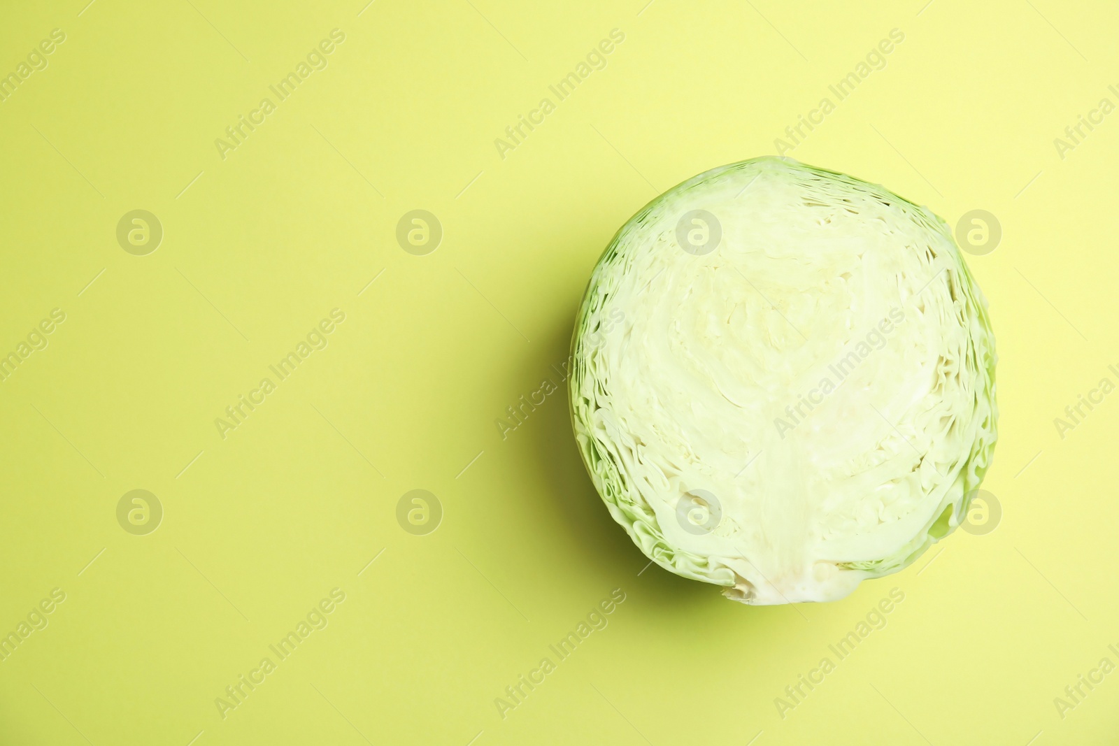 Photo of Cut ripe cabbage on color background, top view