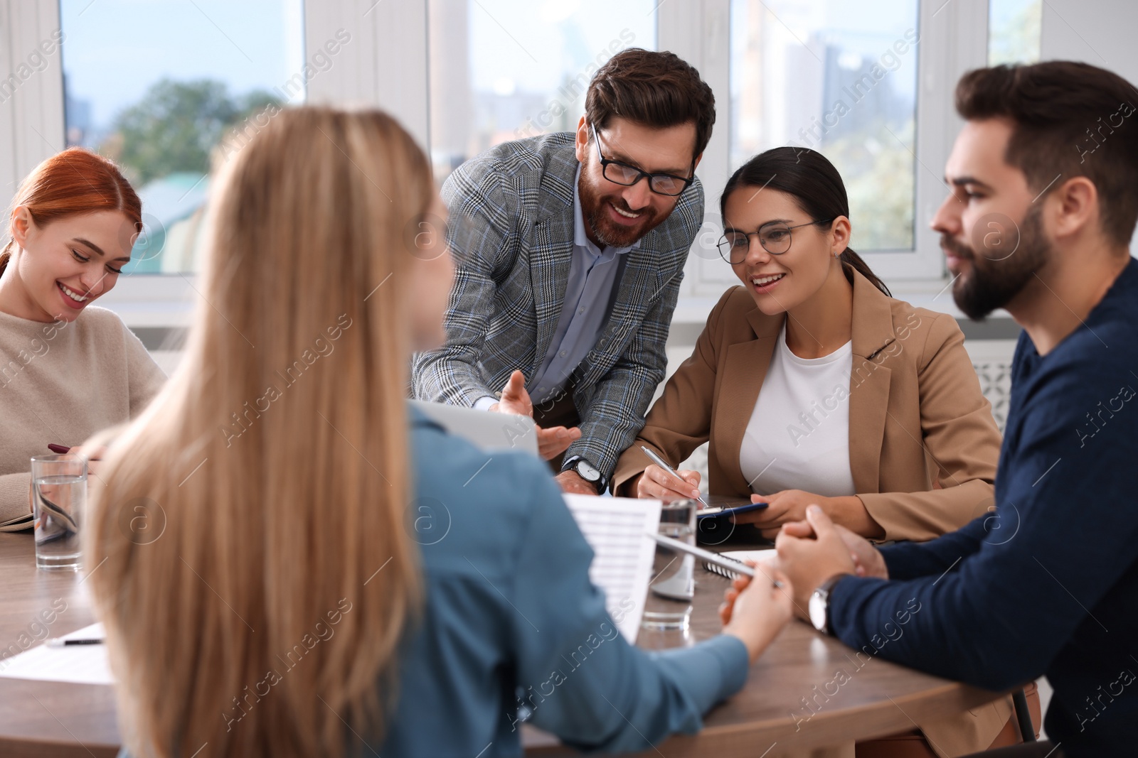 Photo of Team of employees working together in office