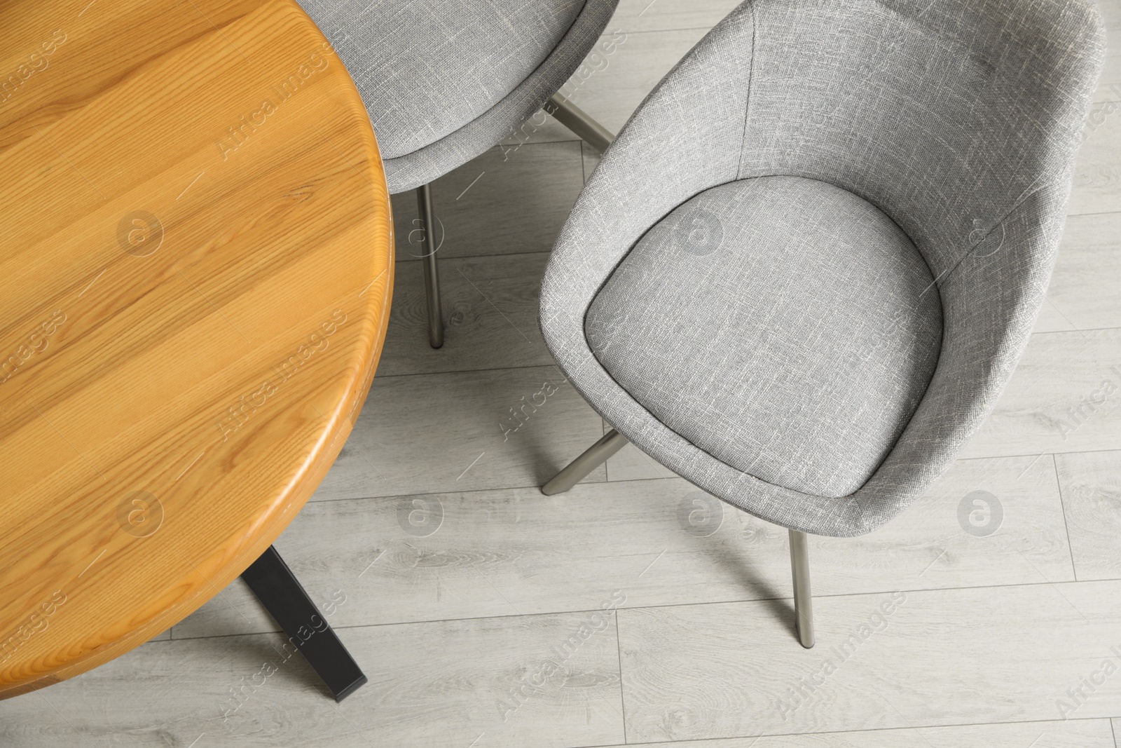 Photo of Stylish comfortable chair near wooden table in room, above view