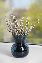 Photo of Beautiful pussy willow branches in vase on window sill