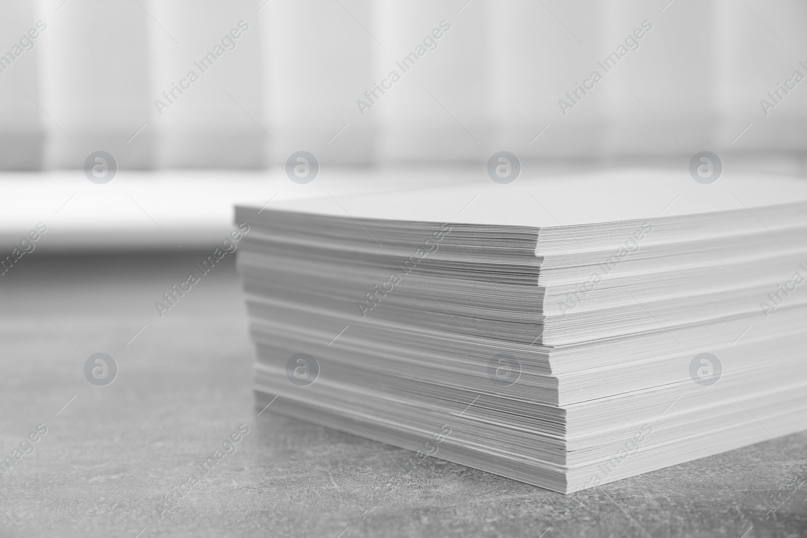 Photo of Stack of paper sheets on grey table, closeup