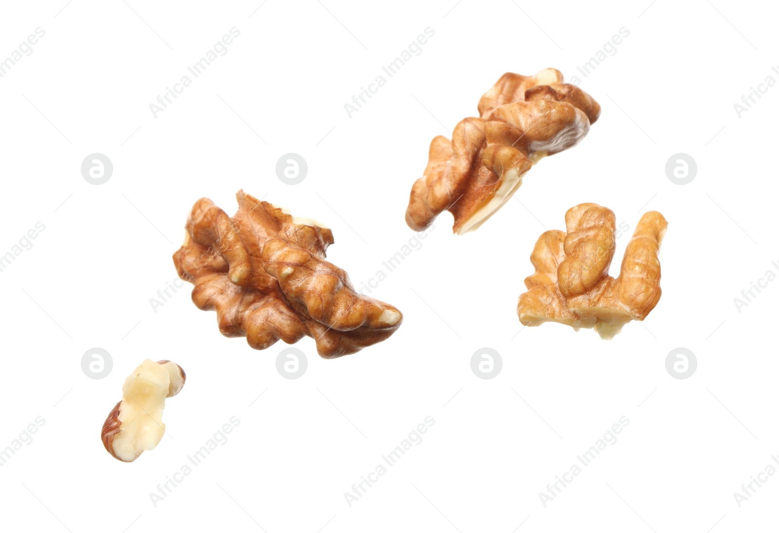 Photo of Pieces of walnut falling on white background