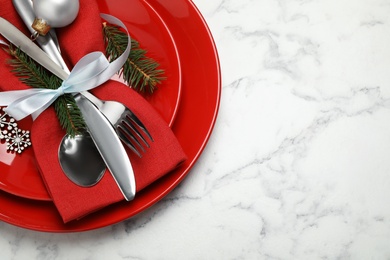 Festive table setting with beautiful dishware and Christmas decor on white marble background, top view. Space for text