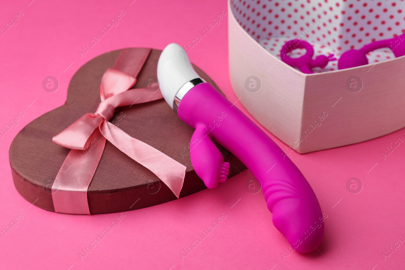 Photo of Gift box with sex toys on pink background