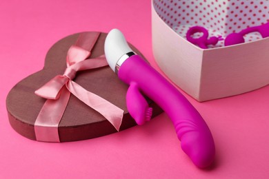 Gift box with sex toys on pink background
