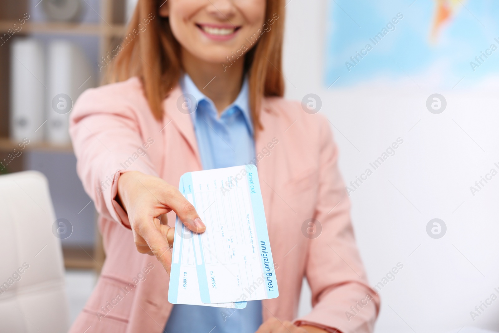 Photo of Female consultant holding tickets in travel agency, closeup