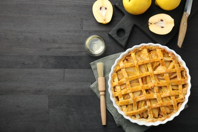 Photo of Tasty homemade quince pie and fresh fruits on black wooden table, flat lay. Space for text