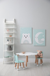 Children's room interior with table and cute pictures on wall