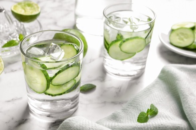 Photo of Glasses with fresh cucumber water on table. Space for text