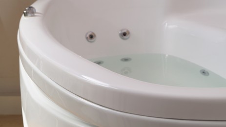 Hot tub with clean water in bathroom, closeup