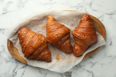 Photo of Tray with tasty croissants on white marble table, top view