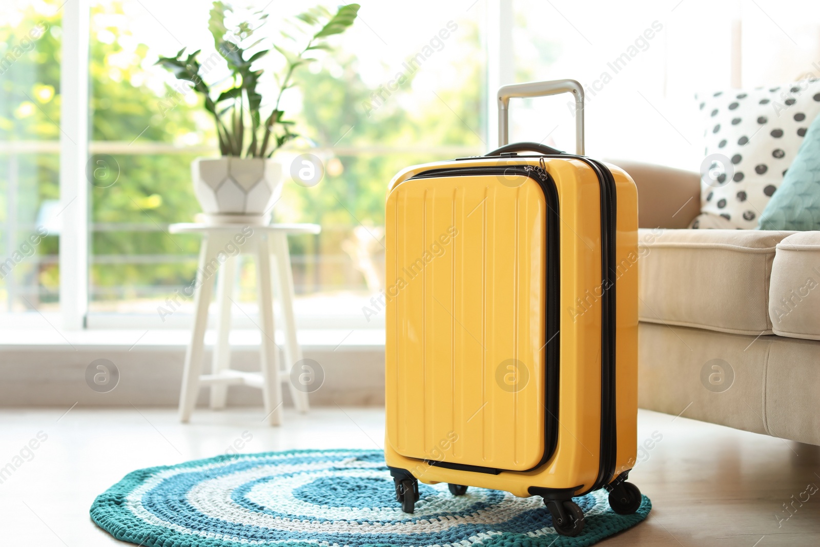 Photo of Bright yellow suitcase packed for journey at home