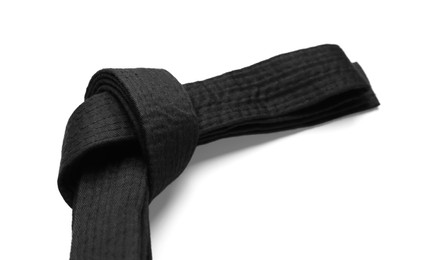 Photo of Tied black belt on white background, closeup. Oriental martial arts