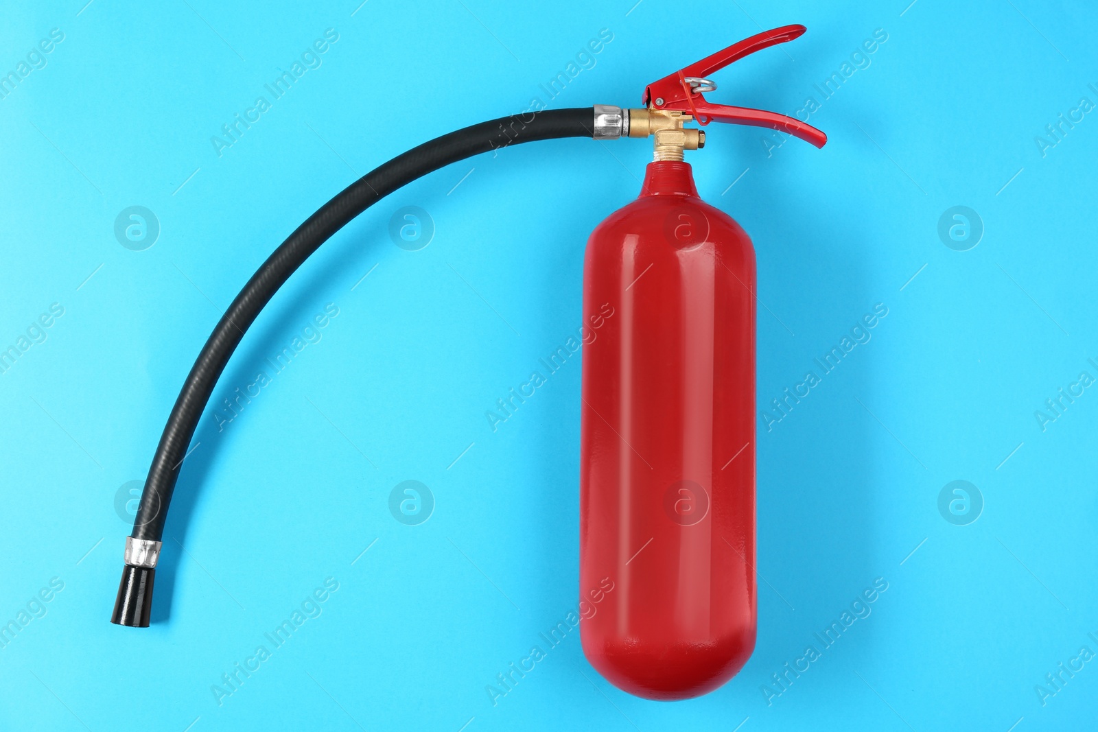 Photo of Fire extinguisher on light blue background, top view