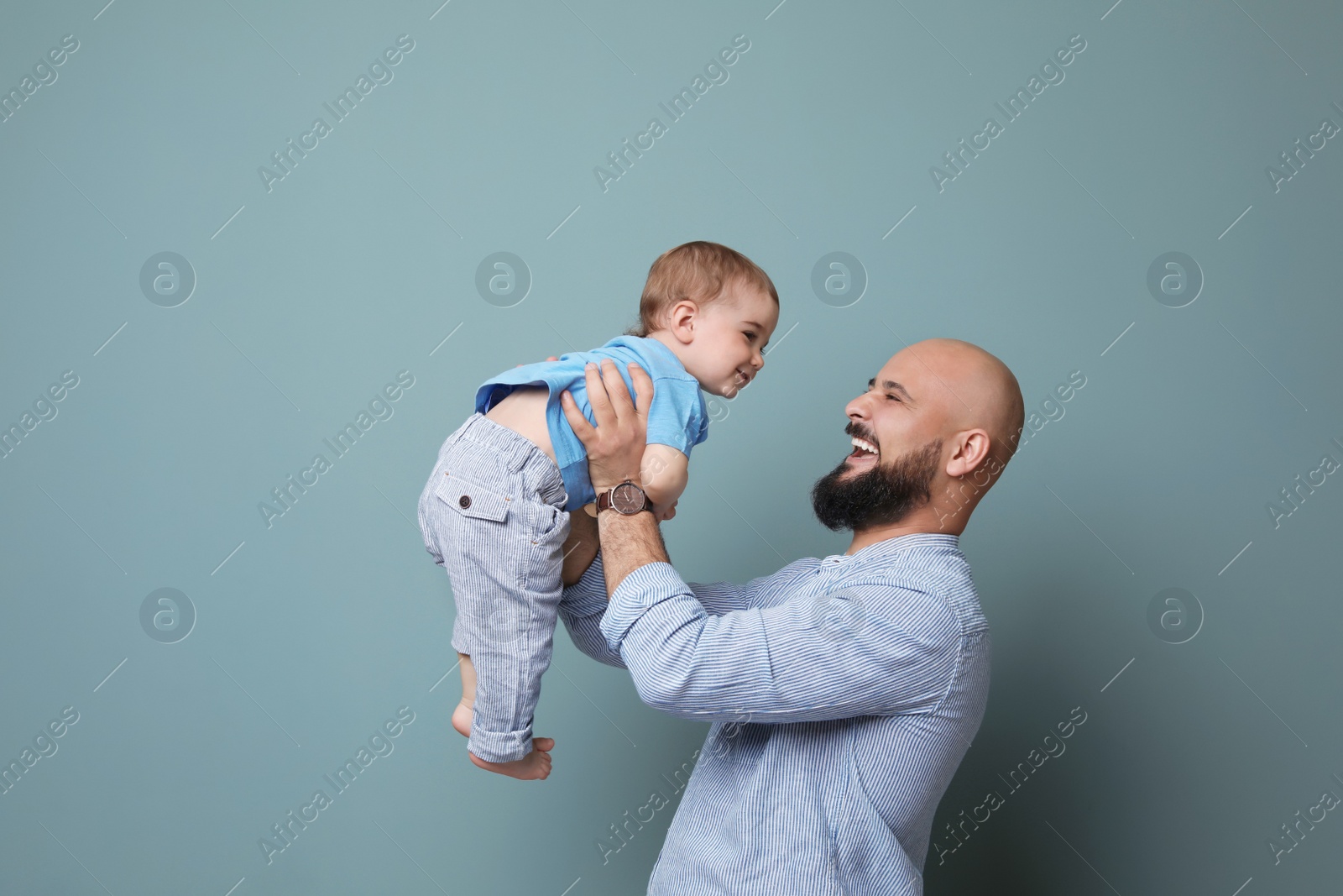 Photo of Portrait of dad and his little son on color background