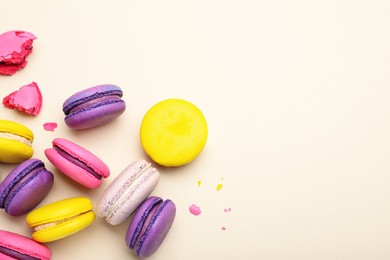 Photo of Delicious colorful macarons on beige background, flat lay. Space for text