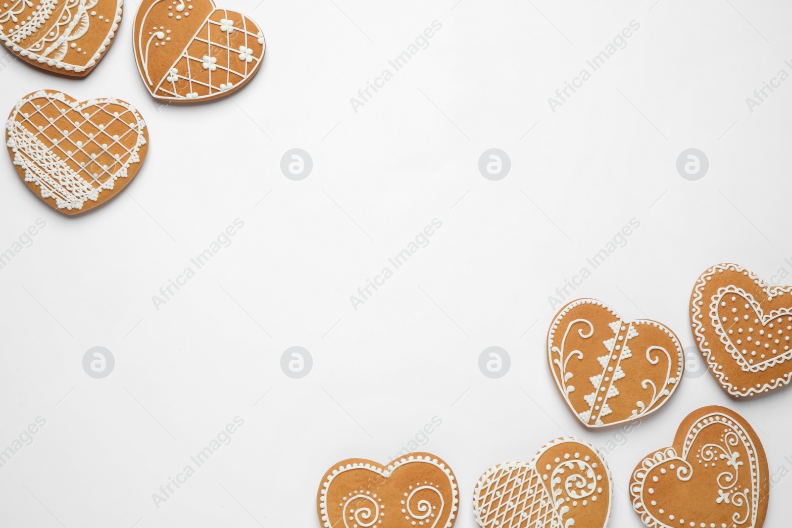 Photo of Gingerbread hearts decorated with icing on white background, flat lay. Space for text