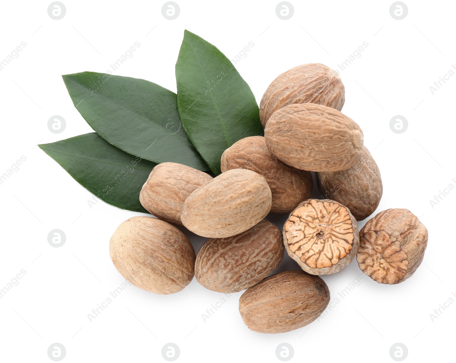 Photo of Whole and cut nutmeg seeds with green leaves on white background, top view