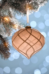 Photo of Christmas tree decorated with holiday bauble against blurred lights, closeup