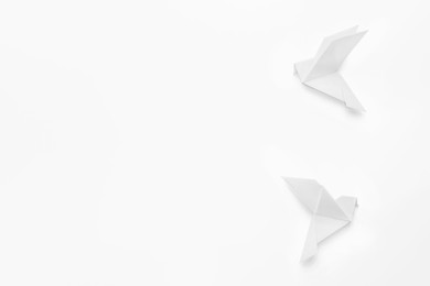 Photo of Beautiful origami birds on white background, flat lay. Space for text