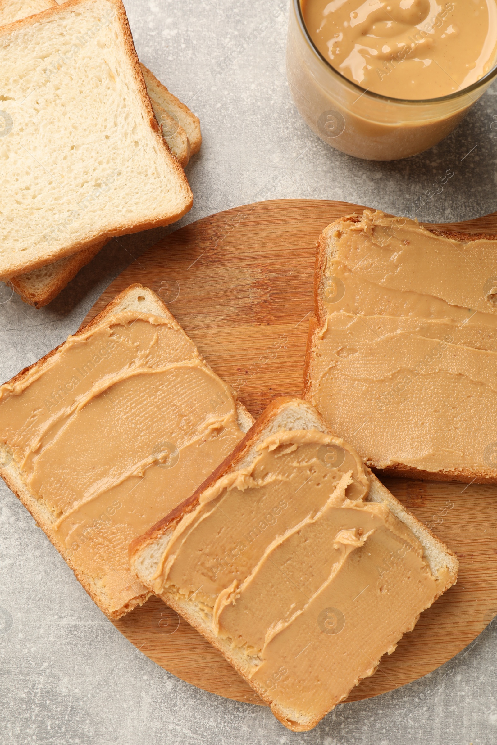 Photo of Tasty peanut butter sandwiches on gray table, flat lay