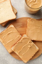 Photo of Tasty peanut butter sandwiches on gray table, flat lay