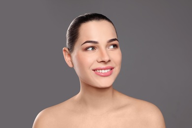 Photo of Portrait of young woman with beautiful face and natural makeup on color background