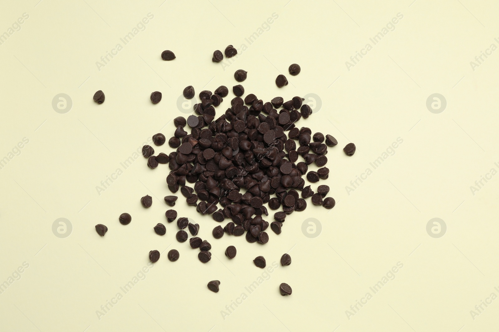 Photo of Pile of delicious chocolate chips on beige background, top view