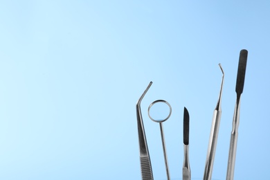 Photo of Set of different dentist tools on color background, closeup. Space for text