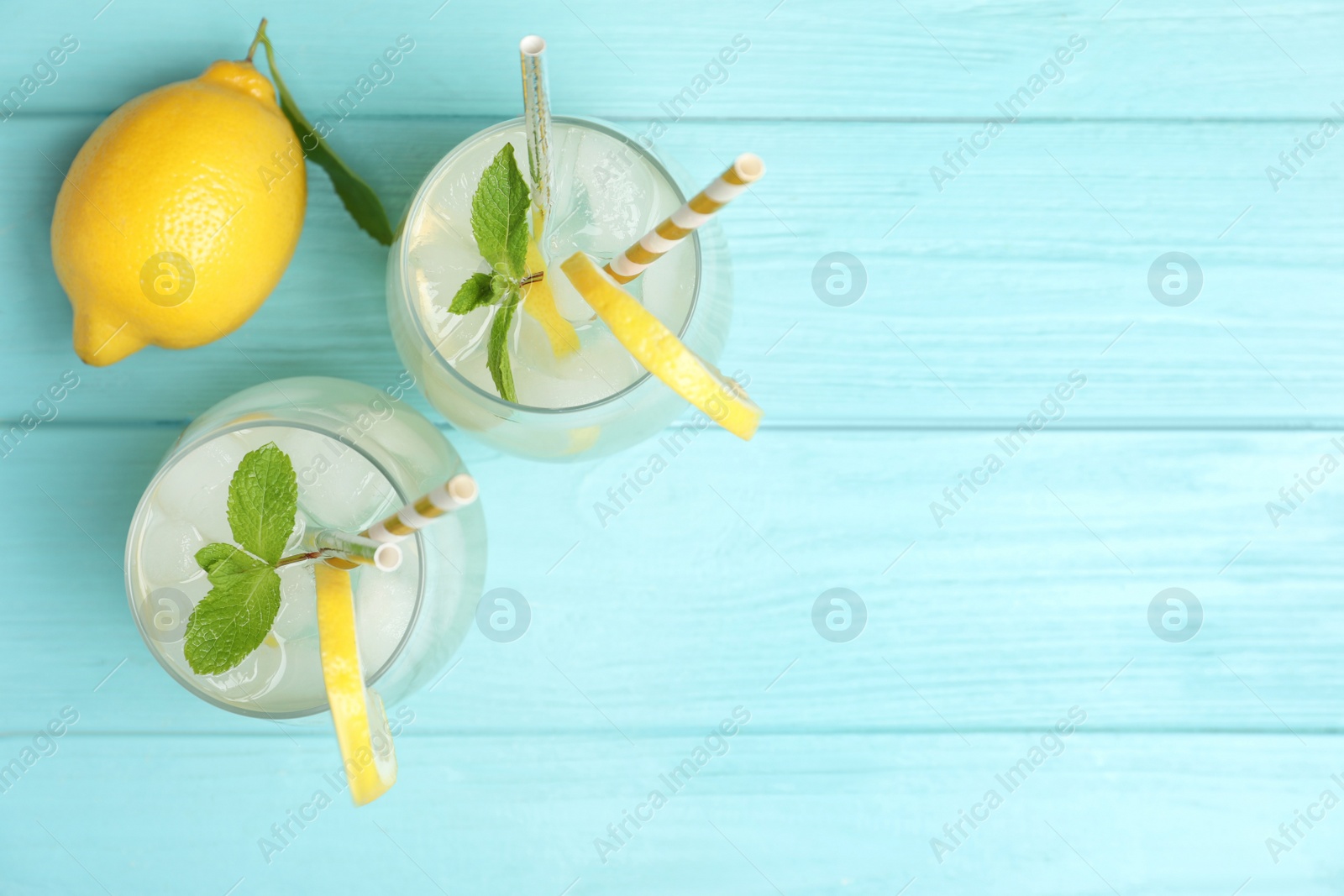 Photo of Natural lemonade with mint on light blue wooden table, flat lay and space for text. Summer refreshing drink