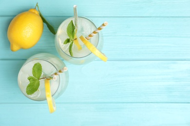 Photo of Natural lemonade with mint on light blue wooden table, flat lay and space for text. Summer refreshing drink