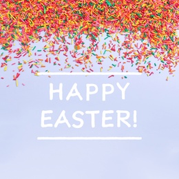 Image of Text Happy Easter and colorful sprinkles on light blue background, flat lay. Confectionery decor