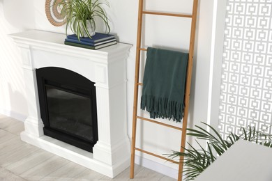 Photo of Wooden ladder near fireplace in stylish room