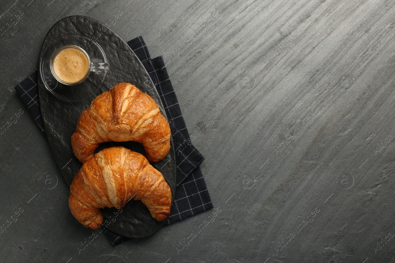 Photo of Delicious fresh croissants and cup of coffee on gray table, flat lay. Space for text