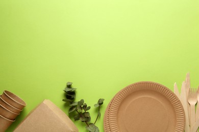 Photo of Flat lay composition with eco friendly products on light green background, space for text