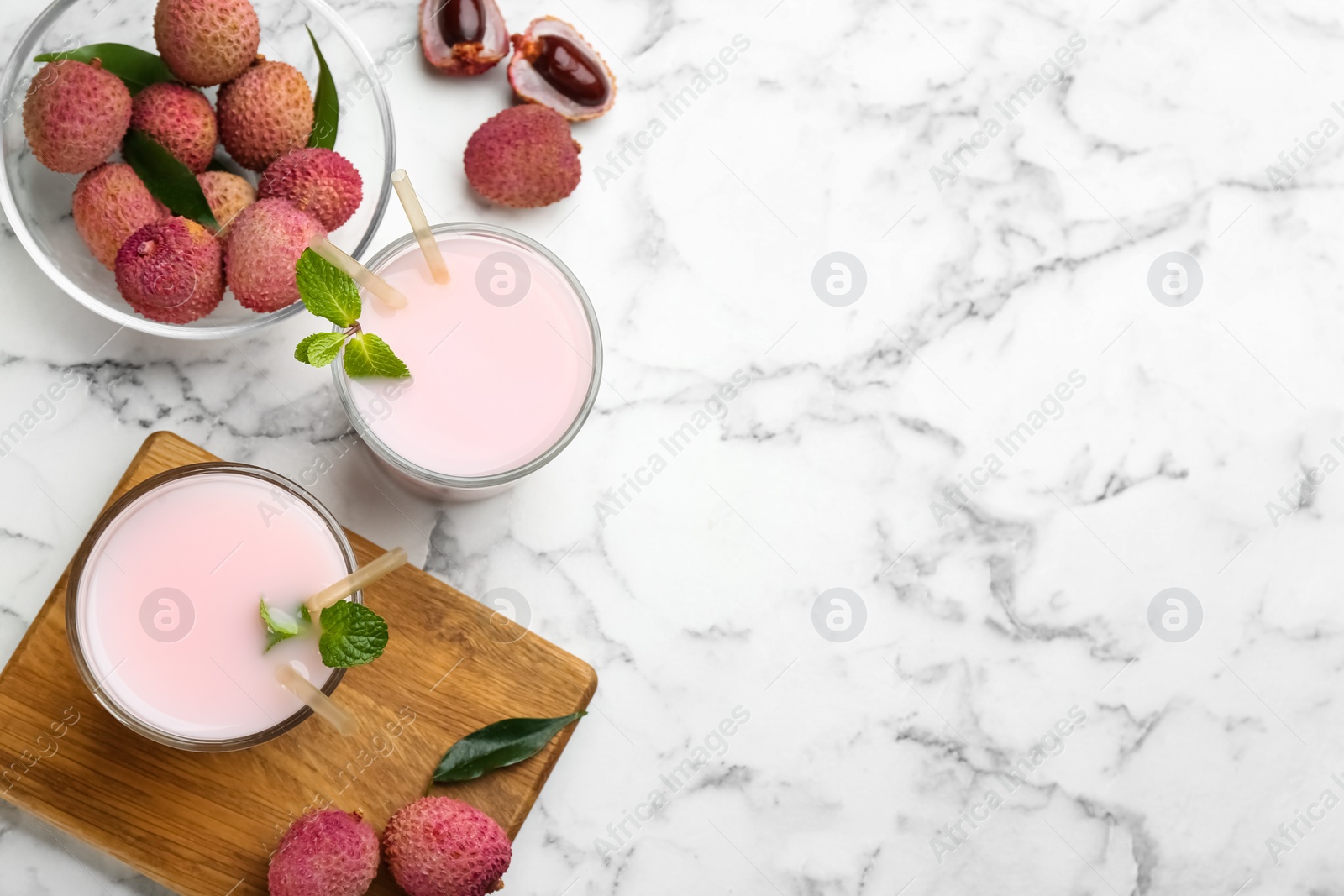 Photo of Flat lay composition with delicious lychee cocktail on white marble table. Space for text