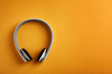 Photo of Wireless headphones on color background, top view. Space for text