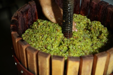 Man working with wooden wine press indoors, closeup