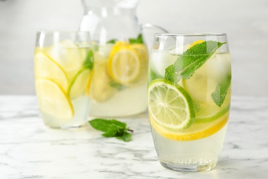 Glass of refreshing lemonade on marble table, space for text. Summer drink