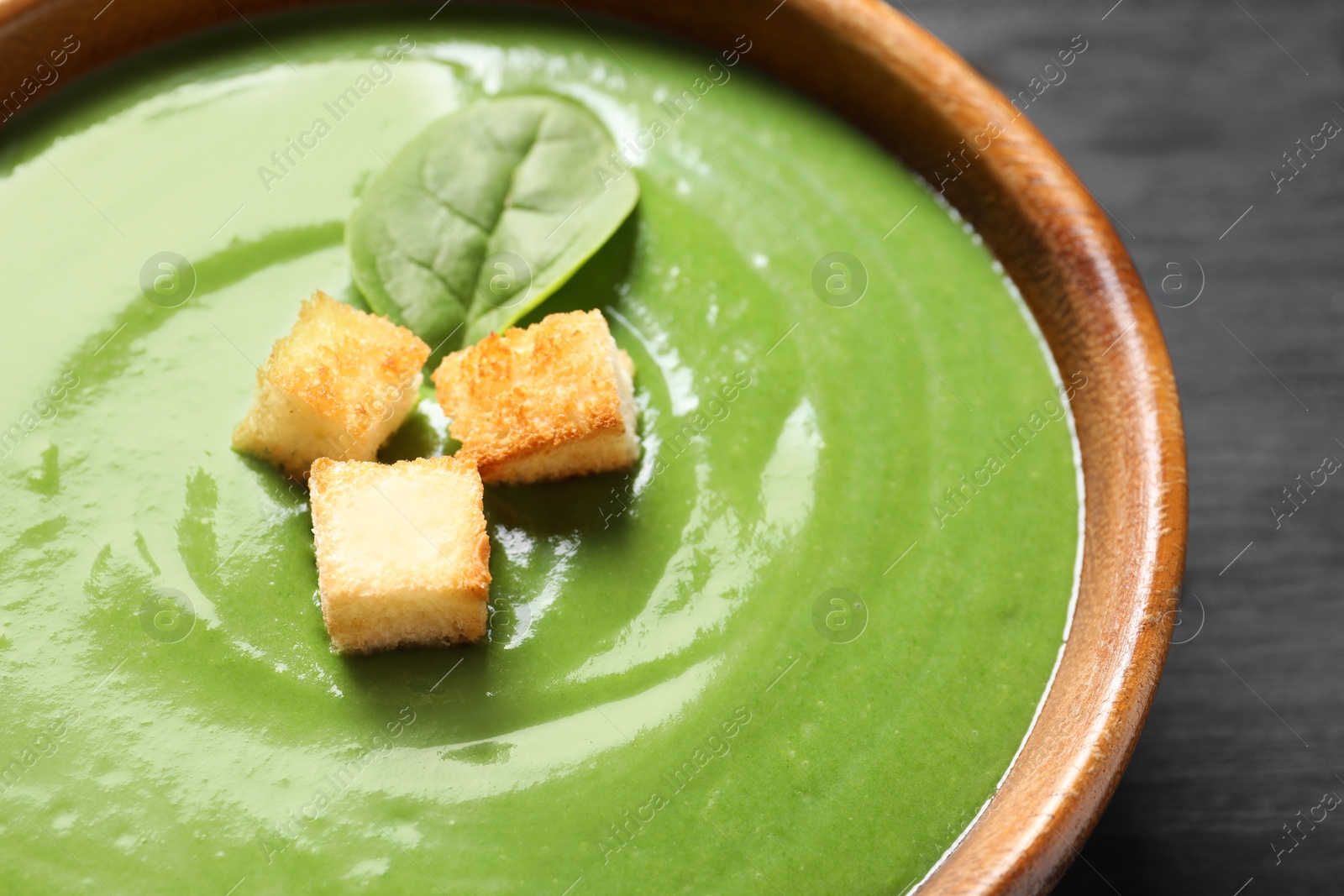 Photo of Fresh vegetable detox soup made of spinach with croutons in dish, closeup