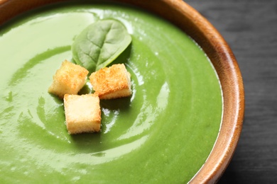 Fresh vegetable detox soup made of spinach with croutons in dish, closeup