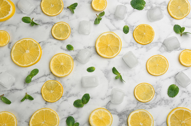 Photo of Lemonade layout with juicy lemon slices, mint and ice cubes on white marble table, top view